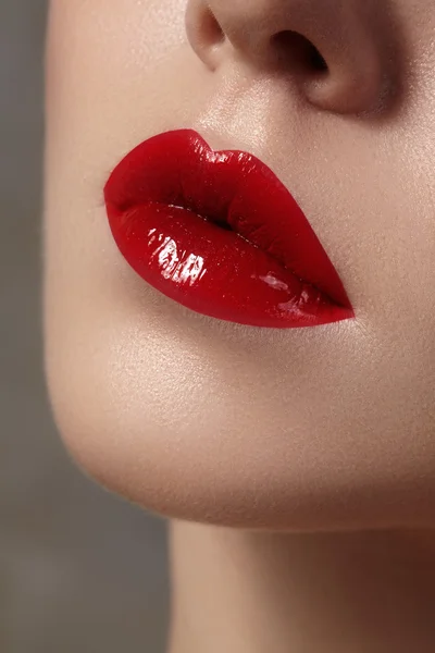 Close-up of female lips with bright makeup. Macro of woman\'s face. Fashion lip make-up with red gloss