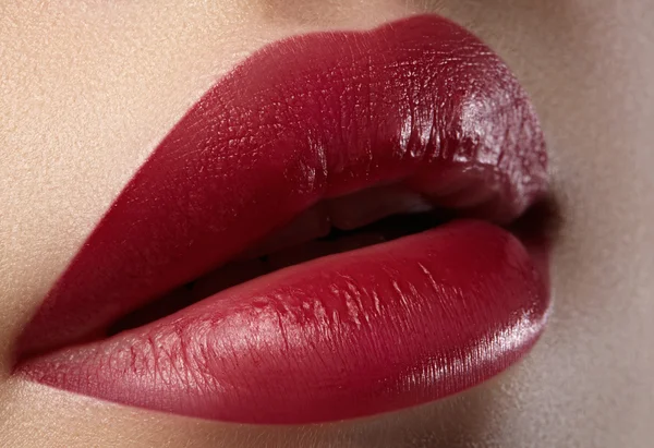 Close-up of female lips with bright makeup. Macro of woman's face. Fashion lip make-up with red lipstick. Horizontal shoot
