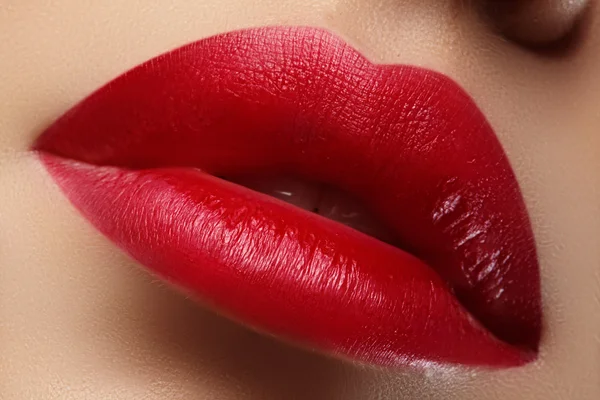 Close-up of woman\'s lips with fashion red make-up. Beautiful female mouth, full lips with perfect makeup. Classic visage. Part of female face. Macro shot of beautiful make up on full lips.