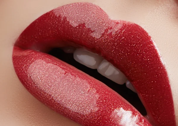 Close-up of female lips with bright makeup. Macro of woman\'s face. Fashion lip make-up with red gloss.Red lipgloss makeup on full female lips