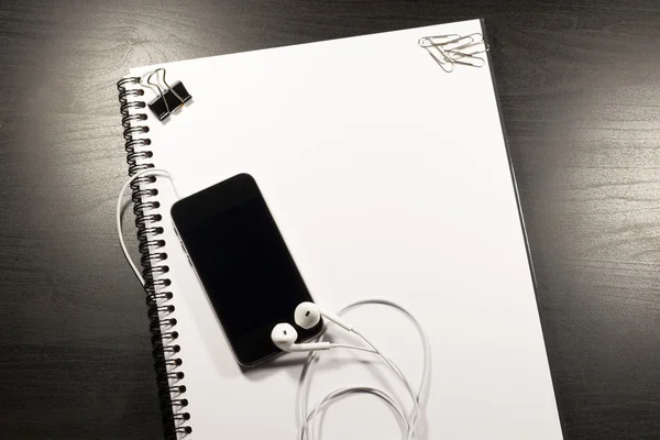 Blank notebook and smartphone