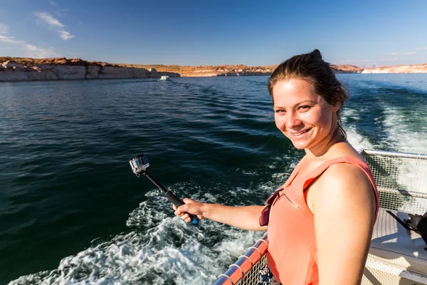 Girl taking selfie with the view of the Glen Canyon on the Lake Powell from boat