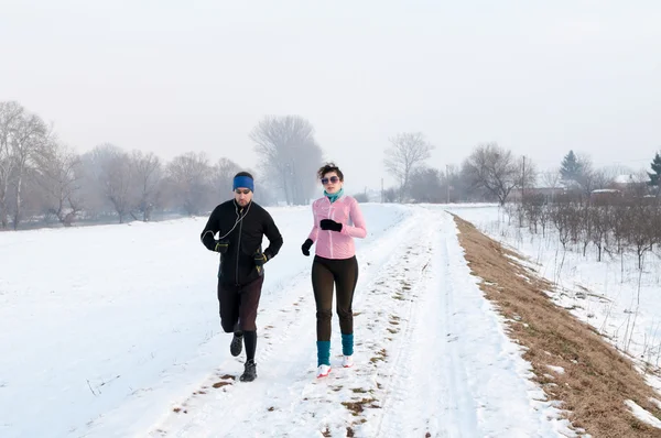 Man and woman running on the snow