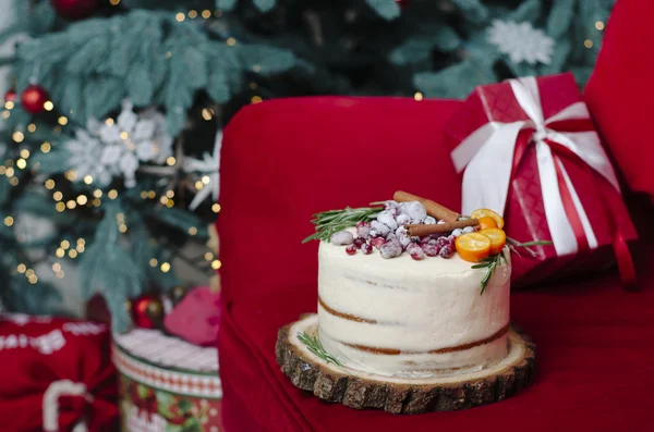 Winter cake near the Christmas tree and gifts