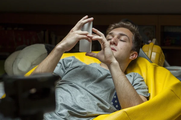 Medium shot portrait of a young man looking at the telephone sit