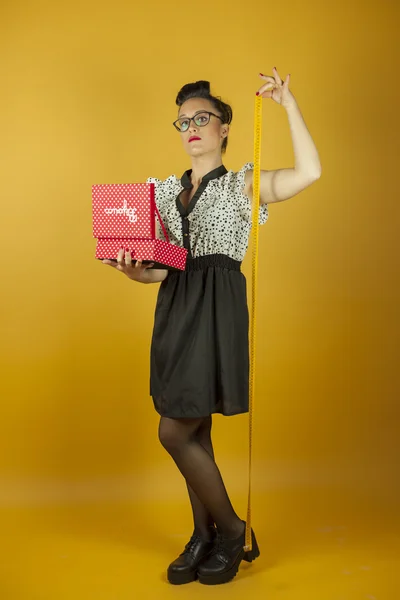 Full shot pin up girl with sewing box, measuring herself