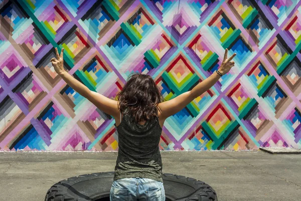 Young womans back with victory gesture at Wynwood Walls in Miami