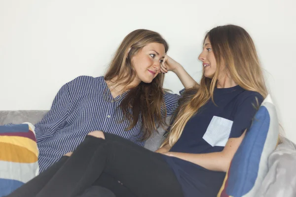 Two beautiful women having a conversation in a sofa