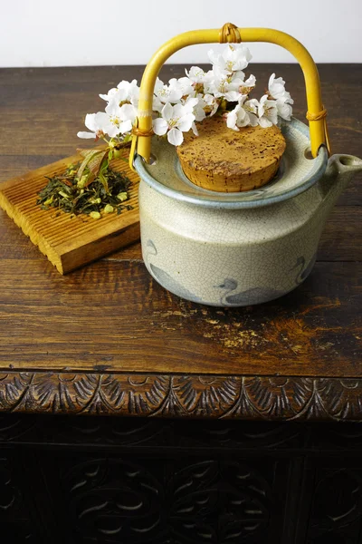 Japan\'s teapot with green tea and sakura flowers