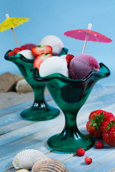 Ice-cream scoops with fresh berries on the beach, summer vacation