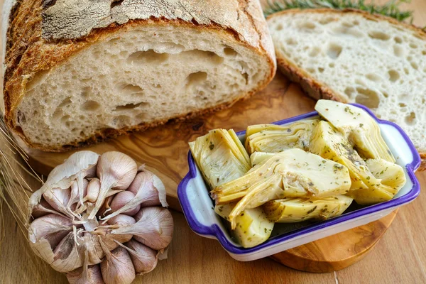 Homemade fresh italian bread and artichokes in brine with spices