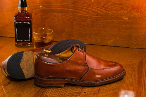 Bottle of whiskey luxury shoes polished.