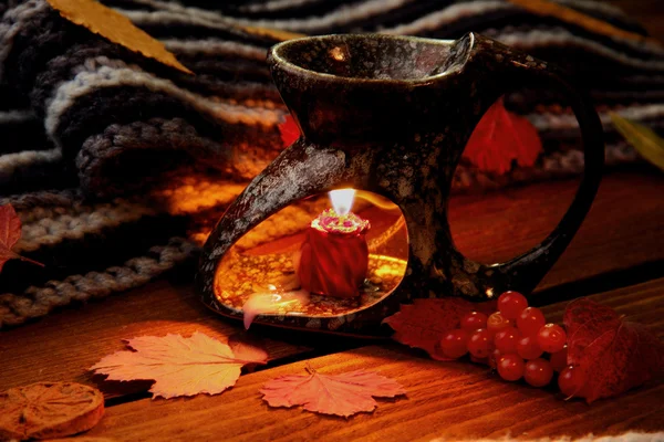 Aroma lamp.Fallen leaves. Autumn theme.Selective focus.Light of candle