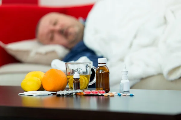 Sick man in bed with drugs and fruit on table