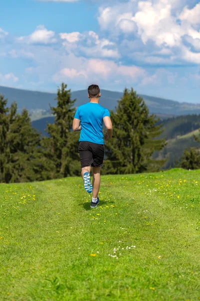 Running fitness man sprinting outdoors in beautiful landscape.