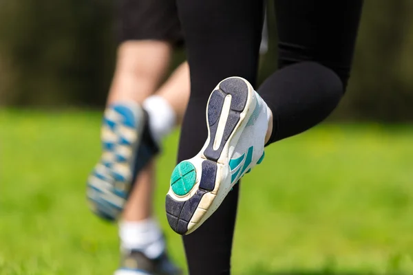 Runner - running shoes closeup of woman and man barefoot running shoes.