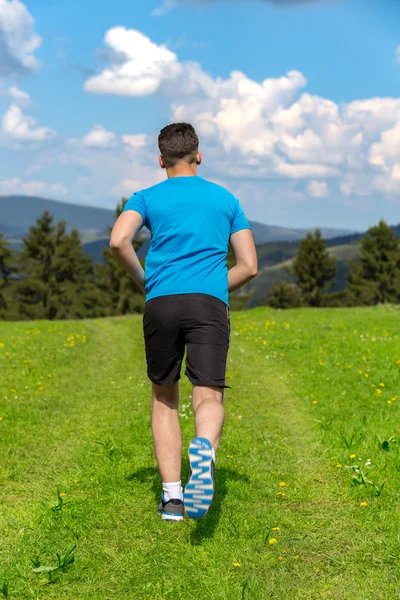 Running fitness man sprinting outdoors in beautiful landscape.
