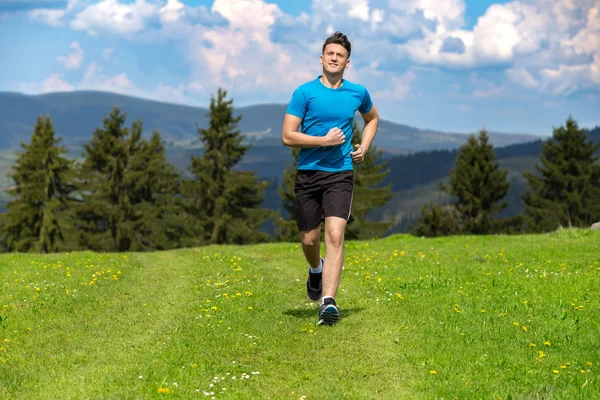 Running fitness man sprinting outdoors in beautiful landscape.