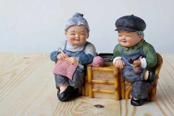 Lovely grandparent doll siting rocking wood chair on wood background