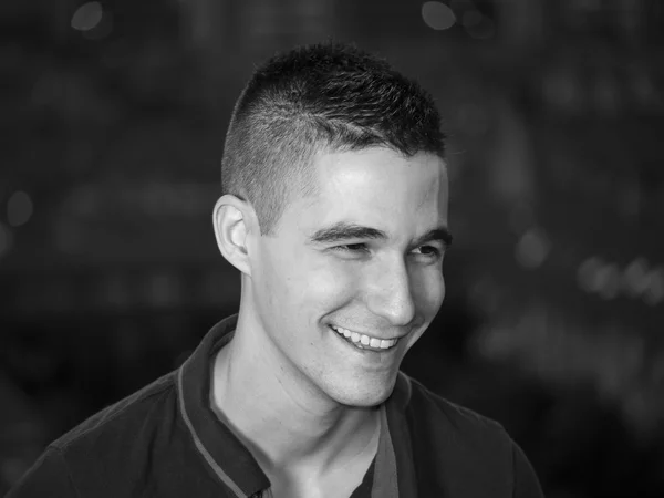 Black and white young man laughing and looking down right