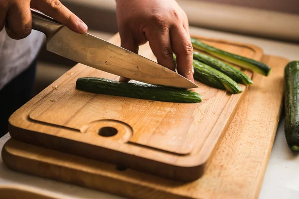 Chef cuts the cucumber