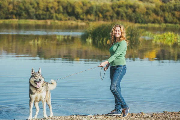 Woman with dog near lake