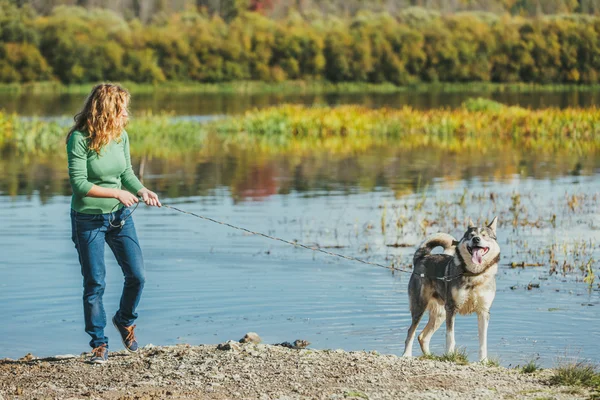 Woman with dog near lake