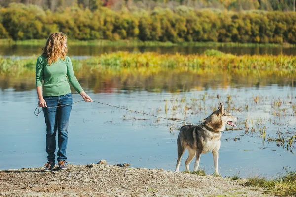 Woman with dog near lake