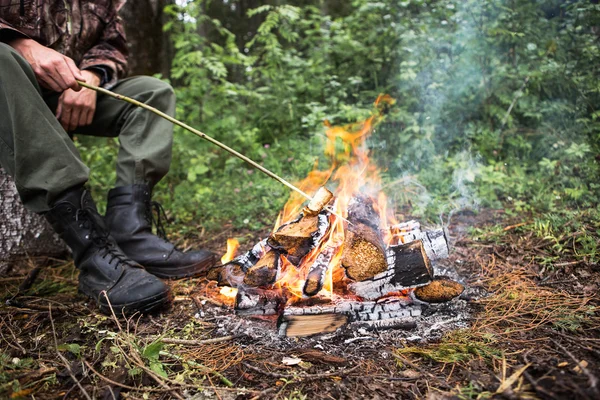 Man roating bread on fire