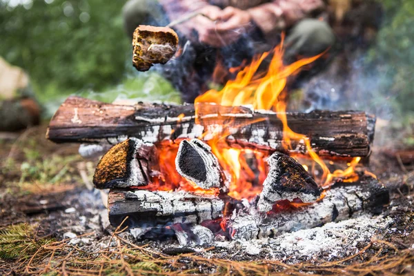 Man roating bread on fire