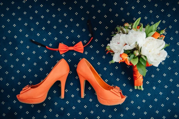 The bow tie, bouquet and shoes in orange color