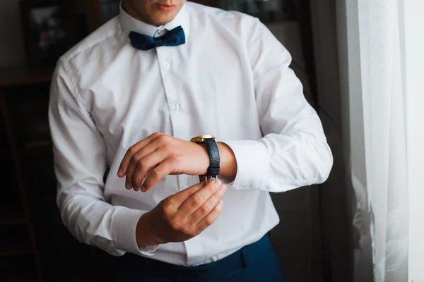 Groom clasping stylish watch band on his wrist