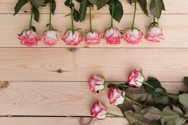 Beautiful pink roses on a dark wooden table