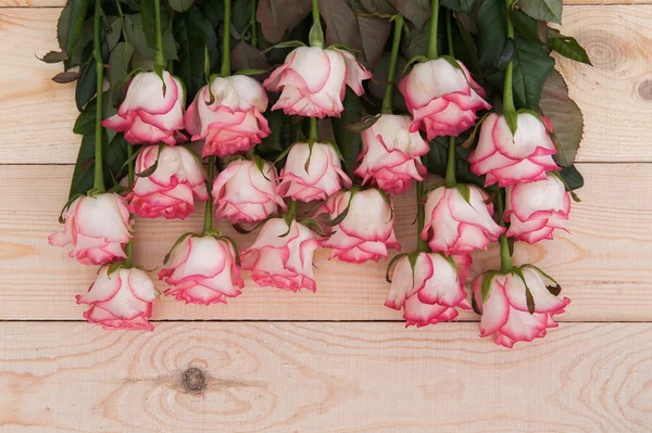 Beautiful pink roses on a dark wooden table