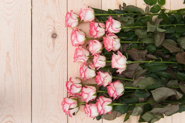 Beautiful pink roses on a dark wooden table