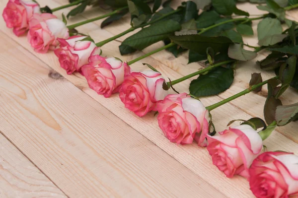 Beautiful pink roses on a dark wooden table