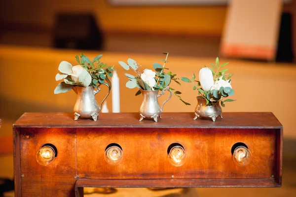 Three small vase with flowers standing near