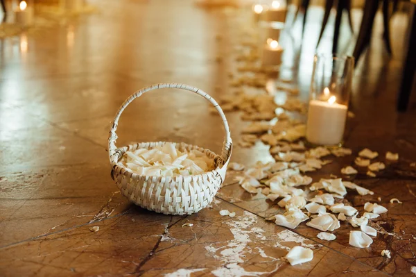 Basket with rose petals on a floor