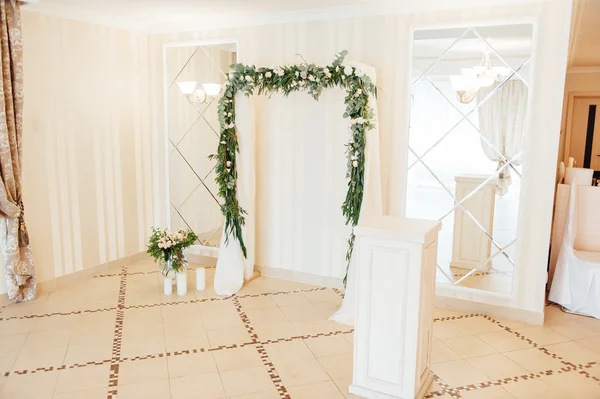 White wedding arch decorated with flower indoor