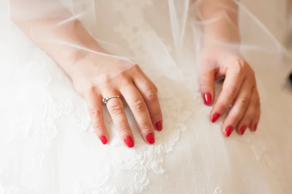 Tender beautiful bride\'s hands on elegant white wedding dress closeup