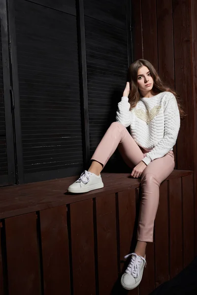 Portrait of beautiful woman in pink pants and white sweater