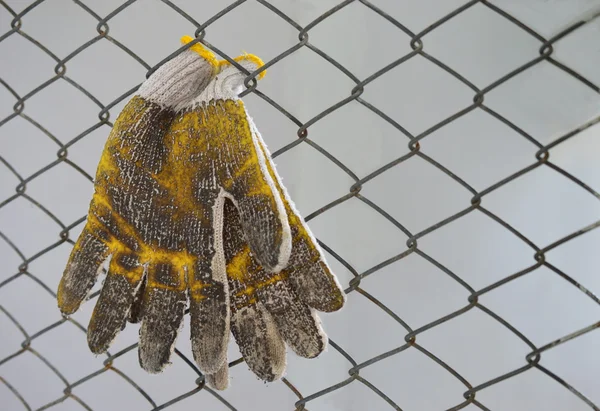 Dirty gloves and wire mesh soft focus on gloves