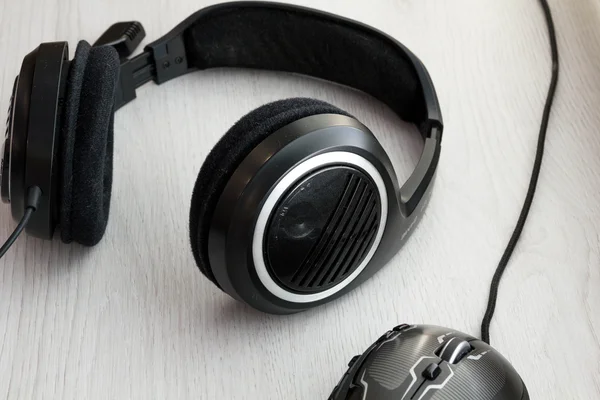 High Angle View of Modern  Audio Headphones with Cord and Mouse on Grey Desk Background with Copy Space