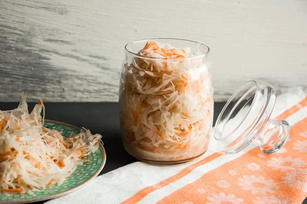 Salad of sauerkraut and carrots in rustic style. Pickled cabbage with carrots. Marinated cabbage in glass jar