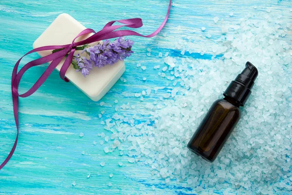 Natural organic soap bottles essential oil and sea salt on a blue wooden table, Spa