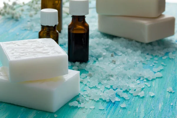 Natural organic soap bottles essential oil and sea salt   on a blue wooden table, Spa