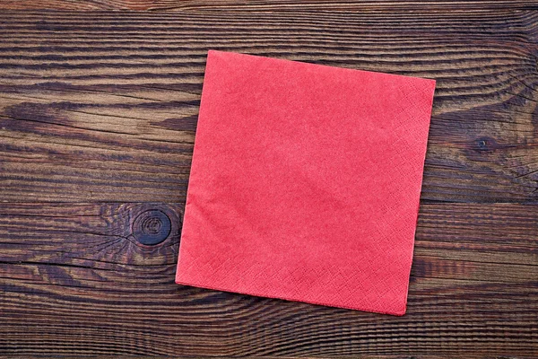 Red paper napkin on wooden table