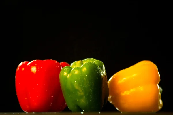 Three colorful bell peppers isolated on black background