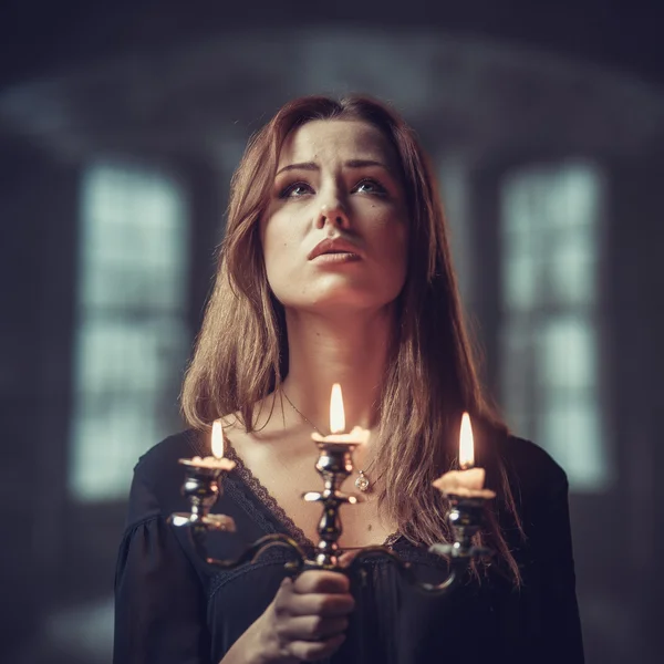 Girl with candles in dark room