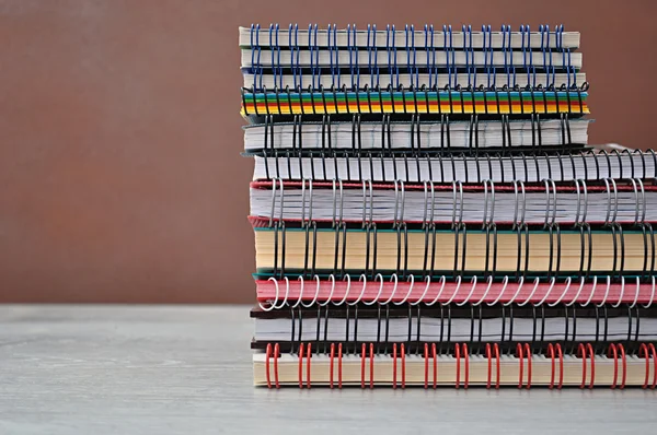 Spiral notebooks stacked on a shelf